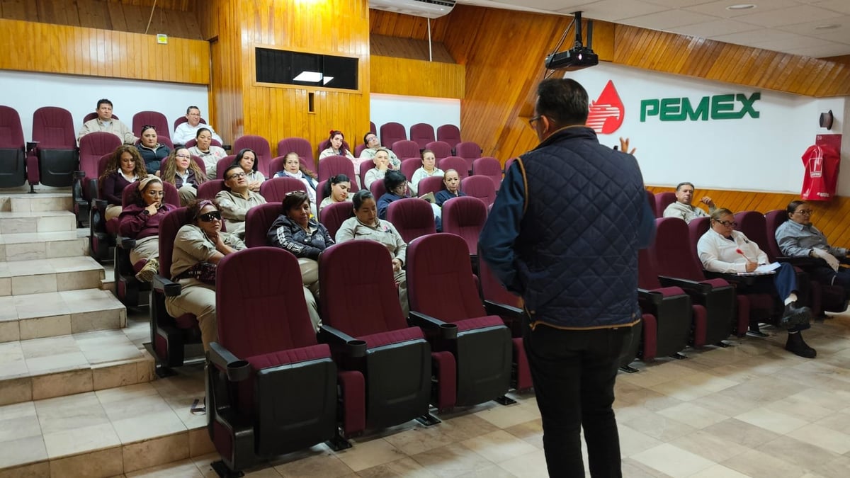 Presentador frente a asistentes sentados en un auditorio con el logotipo de PEMEX en la pared.