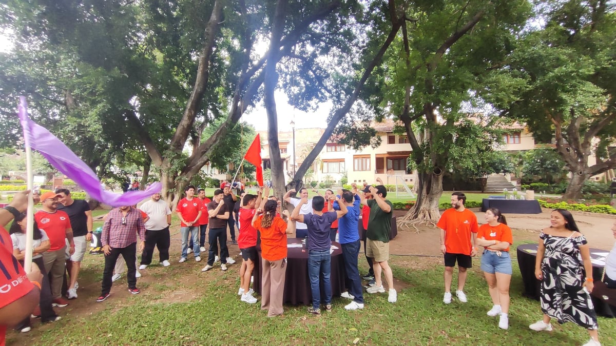 Equipo reunido bajo los árboles en un evento comunitario al aire libre